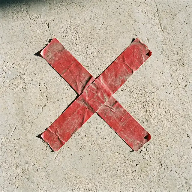 An X of red gaffer tape on a studio floor