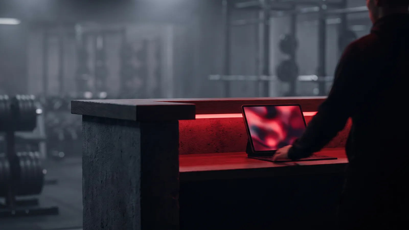 Gym reception desk at night with a tablet showing new sign-ups